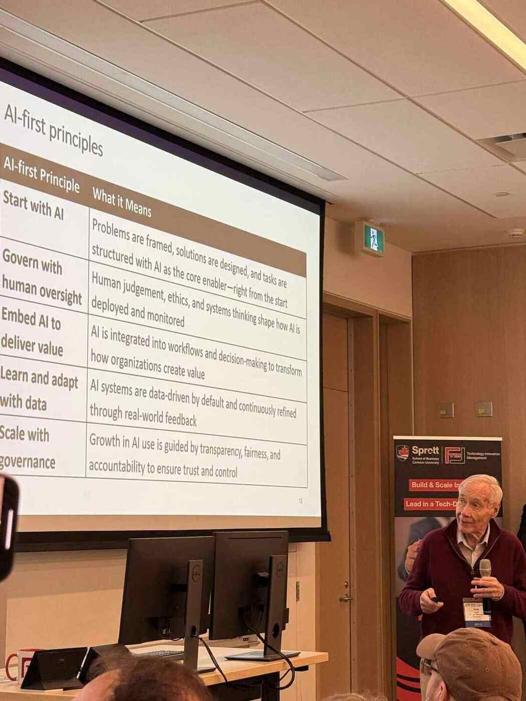 Professor Tony speaking beside an AI-first principles slide during a TIM AI workshop.