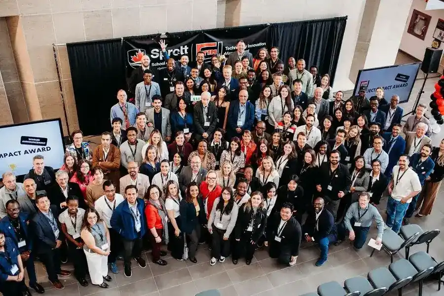 A large TIM community showcase with Professor Tony surrounded by students, founders, and community members.